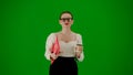 Portrait of attractive office girl on chroma key green screen. Woman in skirt and glasses walking holding red folder and Royalty Free Stock Photo