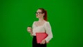 Portrait of attractive office girl on chroma key green screen. Woman in skirt and glasses walking holding red folder and Royalty Free Stock Photo