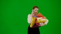 Portrait of attractive office girl on chroma key green screen. Woman talking on smartphone holding stack of folders