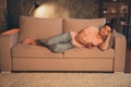 Portrait of attractive peaceful calm guy lying on divan watching tv show late night lamp lighting at home house indoors