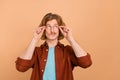 Portrait of attractive pensive intellectual red-haired guy touching specs overthinking isolated over beige pastel color Royalty Free Stock Photo