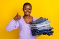 Portrait of attractive person hold stack jeans hand finger demonstrate thumb up isolated on yellow color background Royalty Free Stock Photo