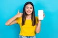 Portrait of attractive positive person demonstrate thumb up empty space telephone display isolated on blue color