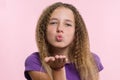 Portrait attractive positive teenage girl sends air kiss over pink background Royalty Free Stock Photo