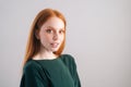 Portrait of attractive redhead young woman model looking at camera on white background in professional studio. Royalty Free Stock Photo