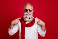 Portrait of attractive retired man in eyeglasses eyewear pointing at his beard with collection of glass balls wearing