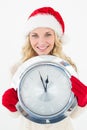 Portrait of attractive santa woman holding clock