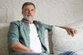 Portrait of attractive senior man sitting in sofa at home. Royalty Free Stock Photo