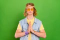 Portrait of attractive serene guy praying wish want beg religion rest  over bright green color background Royalty Free Stock Photo