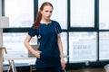 Portrait of attractive serious female doctor wearing medical uniform looking at camera standing on background of window. Royalty Free Stock Photo