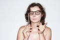 Portrait of attractive brunette woman with mask of glasses on stick. Pretty girl points finger Royalty Free Stock Photo