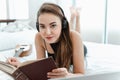 Portrait of Attractive Sexy Woman is Relaxing on Bedroom While Listen Music on Headphones, Beautiful Caucasian Girl Lying Down on Royalty Free Stock Photo