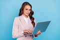 Portrait of attractive skilled focused woman using laptop writing report isolated over bright blue color background Royalty Free Stock Photo