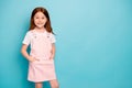 Portrait of attractive small child she her hands plams pocket standing isolated over blue background