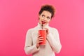 Portrait of an attractive smiling girl drinking from a plastic cup Royalty Free Stock Photo