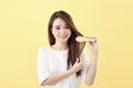 Portrait of attractive smiling woman brushing her hair isolated on yellow studio shot Royalty Free Stock Photo