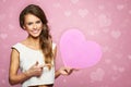 Portrait of attractive smiling woman dark hair isolated on pink studio shot with heart. Happy in Love Royalty Free Stock Photo