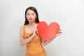 Portrait of attractive smiling woman holding red heart on white background Royalty Free Stock Photo