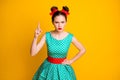 Portrait of attractive strict serious girl wearing dotted teal dress threatening forefinger isolated over vivid yellow