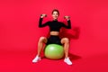 Portrait of attractive strong endurant cheerful girl working out lifting equipment isolated over bright red color Royalty Free Stock Photo