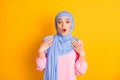 Portrait of attractive stunned worried muslimah wearing hijab take me omg news reaction isolated on bright yellow color