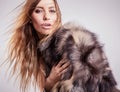 Portrait of attractive stylish woman in fur against grey background. Royalty Free Stock Photo
