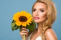 Portrait of attractive summer woman with sunflower in hand