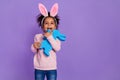 Portrait of attractive trendy cheerful sweet pre-teen girl holding bunny copy space isolated over bright purple violet Royalty Free Stock Photo