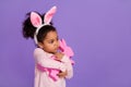 Portrait of attractive trendy pre-teen girl hugging bunny toy shop store copy space isolated over bright purple violet Royalty Free Stock Photo