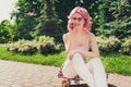 Portrait of attractive wavy-haired cheerful girl sitting on skate talking on phone spending free time on fresh air Royalty Free Stock Photo