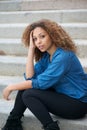 Portrait of an attractive woman with curly hair sitting outdoors