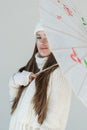 portrait of attractive woman in fashionable winter sweater and scarf standing with japanese umbrella isolated Royalty Free Stock Photo