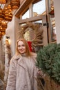 Portrait of attractive woman in a fur coat on Christmas decorations background, festive street. Christmas mood. Holiday weekend Royalty Free Stock Photo