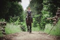 Portrait of attractive woman galloping on black hanoverian stallion horse