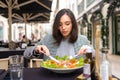 Portrait attractive woman in glasses eating salad at cafe table. Royalty Free Stock Photo