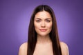 Portrait of attractive woman perfect flawless clean skin isolated over bright violet purple color background