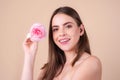 Portrait of attractive woman with pink rose on beige background. Portrait of a happy beautiful young girl with a pink Royalty Free Stock Photo