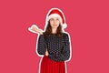 Portrait of attractive woman pointing up with index finger. emotional girl in santa claus christmas hat Magazine collage style