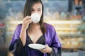 Portrait of attractive woman in a purple nightgown and silk robe holding a white cup of tea on a white background. Royalty Free Stock Photo