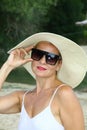 Portrait of an attractive woman with sunglasses and a hat on the beach Royalty Free Stock Photo