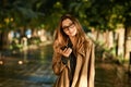 Portrait of attractive woman using cell phone while walking through empty boulevard Royalty Free Stock Photo