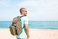 Portrait of attractive young African-American hipster wearing t-shirt and sunglasses walking at summer day on the beach Royalty Free Stock Photo