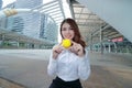 Portrait of attractive young Asian business woman with yellow ball in the urban building city background. Royalty Free Stock Photo