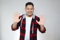 Portrait of attractive young Asian man shows hi or high five gesture with his fingers Royalty Free Stock Photo