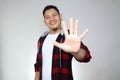 Portrait of attractive young Asian man shows hi or high five gesture with his fingers Royalty Free Stock Photo