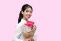 Portrait of attractive young Asian woman holding a bouquet of red roses on pink isolated background. Valentine`s day concept. Royalty Free Stock Photo