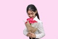 Portrait of attractive young Asian woman holding a bouquet of red roses on pink isolated background. Valentine`s day concept. Royalty Free Stock Photo