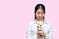 Portrait of attractive young Asian woman holding white rose on pink isolated background. Valentines day concept. Royalty Free Stock Photo