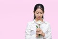 Portrait of attractive young Asian woman holding white rose on pink isolated background. Valentines day concept. Royalty Free Stock Photo