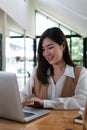 Portrait of an attractive young Asian woman working on laptop. Royalty Free Stock Photo